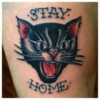Tatuaje de gato que bufa y frase queda en casa
