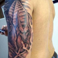 Tatuaje en el brazo, 
pirámides con la estatua de dios Anubis y anj