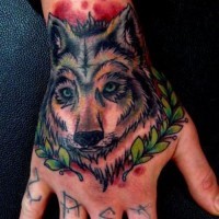 Tatuaje en la mano,  cara de lobo bonito y corona de laurel