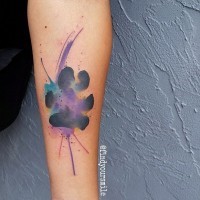 Tatuaje en el antebrazo, huella negra con mancha purpura