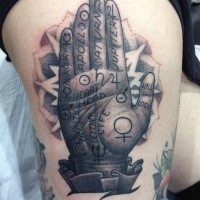 Homemade style black and white human hand tattoo on thigh stylized with lettering