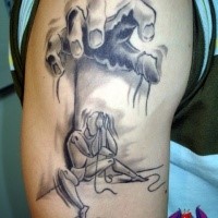 Homemade style black ink shoulder tattoo of human hand with puppet