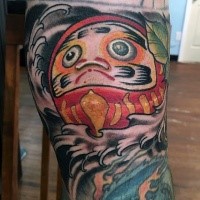 Homemade style colored leg tattoo of funny daruma doll with leaves