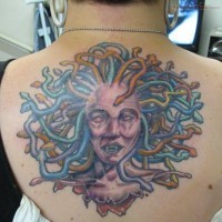 Homemade style colored upper back tattoo of severed Medusa`s head
