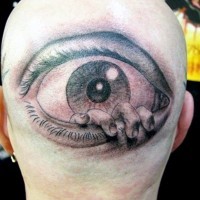 Horrifying like painted black and white eye with hand tattoo on head
