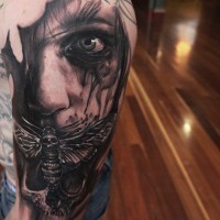 Erschreckender gemalter schwarzweißer mystischer Mann mit Insekten und Schädel Tattoo an der Schulter