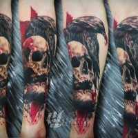 Blutiger menschlicher Schädel Horror Tattoo am Unterarm mit erschreckender Krähe