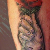 Horror movie like red colored rose in zombies hand tattoo on leg