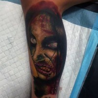 Horrorfilm Stil mehrfarbiges Bein Tattoo mit Gesicht des Zombies Frau