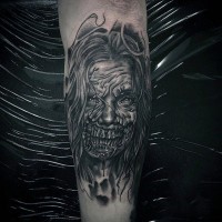 Horror style black and white forearm tattoo of creepy monster woman