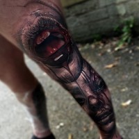 Tatuaje en la pierna,
la boca y la cara aterradores en sangre