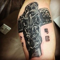 Horror style colored biceps tattoo of large cross with lettering