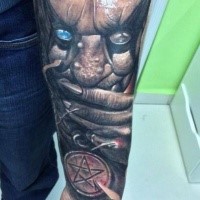Horror style colored forearm tattoo of monster with blue eye