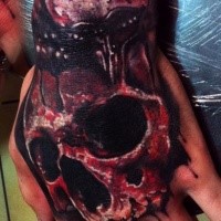 horror style colored hand tattoo of bloody human skull part
