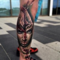 Horror style colored leg tattoo of bloody arm with woman face