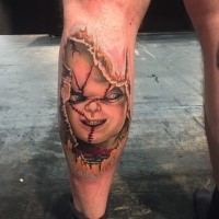 Horror style colored leg tattoo of creepy doll face