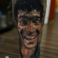 Horror style colored leg tattoo of man face with injuries