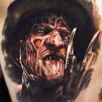 Horror style colored thigh tattoo of Freddy Kruger face