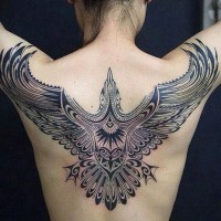 Huge dark black ink flying bird tattoo on back in tribal style