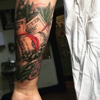 Hundred dollars banknotes and weed leaves colored lifelike tattoo on arm