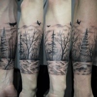 Illustrative style black and white forearm tattoo of dark forest and crows