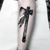 Illustrative style black ink Indian axe tattoo on leg
