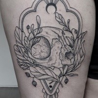 Illustrative style black ink thigh tattoo of cat skull with plants