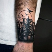 Illustrative style black ink wrist tattoo of mountain forest and birds