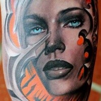 Illustrative style colored biceps tattoo of woman portrait with blue eyes