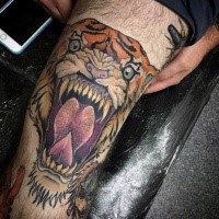 Illustrative style colored demonic roaring tiger tattoo on leg