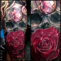 Illustrative style colored forearm tattoo of human skull with jewelry and rose