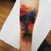 Illustrative style colored forearm tattoo of tree with birds