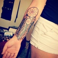 Illustrative style colored forearm tattoo of dream catcher