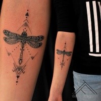 Illustrative style colored forearm tattoo of dragonfly with ornaments