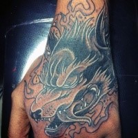 Illustrative style colored hand tattoo of wolf with smoke