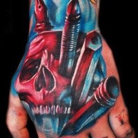 Illustrative style colored hand tattoo of creepy skull with pencils and pens