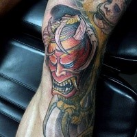 Illustrative style colored leg tattoo of demonic mask