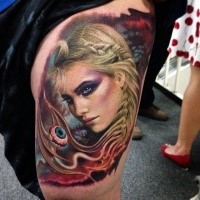 Illustrative style colored thigh tattoo of fantasy woman with creepy eye