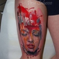 Illustrative style colored thigh tattoo of woman face with paint and brushes