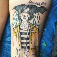 Illustrative style colored thigh tattoo of woman with umbrella and lettering