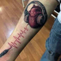 Impressive 3D like colored music themed heart with headset tattoo on arm