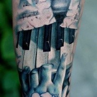 Beeindruckende im Realismus Stil farbige Klaviertaste mit spielender Hand Tattoo am Unterarm
