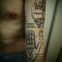 Tatuaje en el brazo, combinación de árbol, mano y inscripciones, colores negro blanco