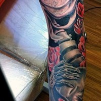 Tatuaje en el brazo, esqueleto volumétrico con rosas rojas