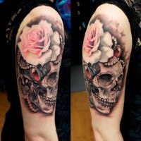 Incredible multicolored shoulder tattoo of human skull and flowers with jewelry