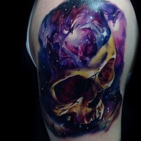 Incredible painted and colored big skull stylized with space tattoo on upper arm