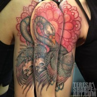 Tatuaje en el hombro, pájaro fantástico con cráneo humano y encaje rojo elegante
