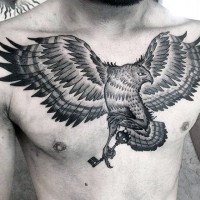 Indian style black and white eagle tattoo on chest with little antic key