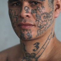 Verrückte Tattoos in Tusche auf dem Gesicht