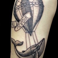 Tatuaje en el brazo, globo con ballena divertida y inscripción